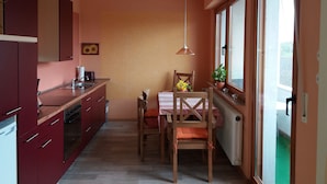 Une cuisine compacte avec un coin repas, des chaises en bois, une table et une fenêtre donnant sur un beau paysage.