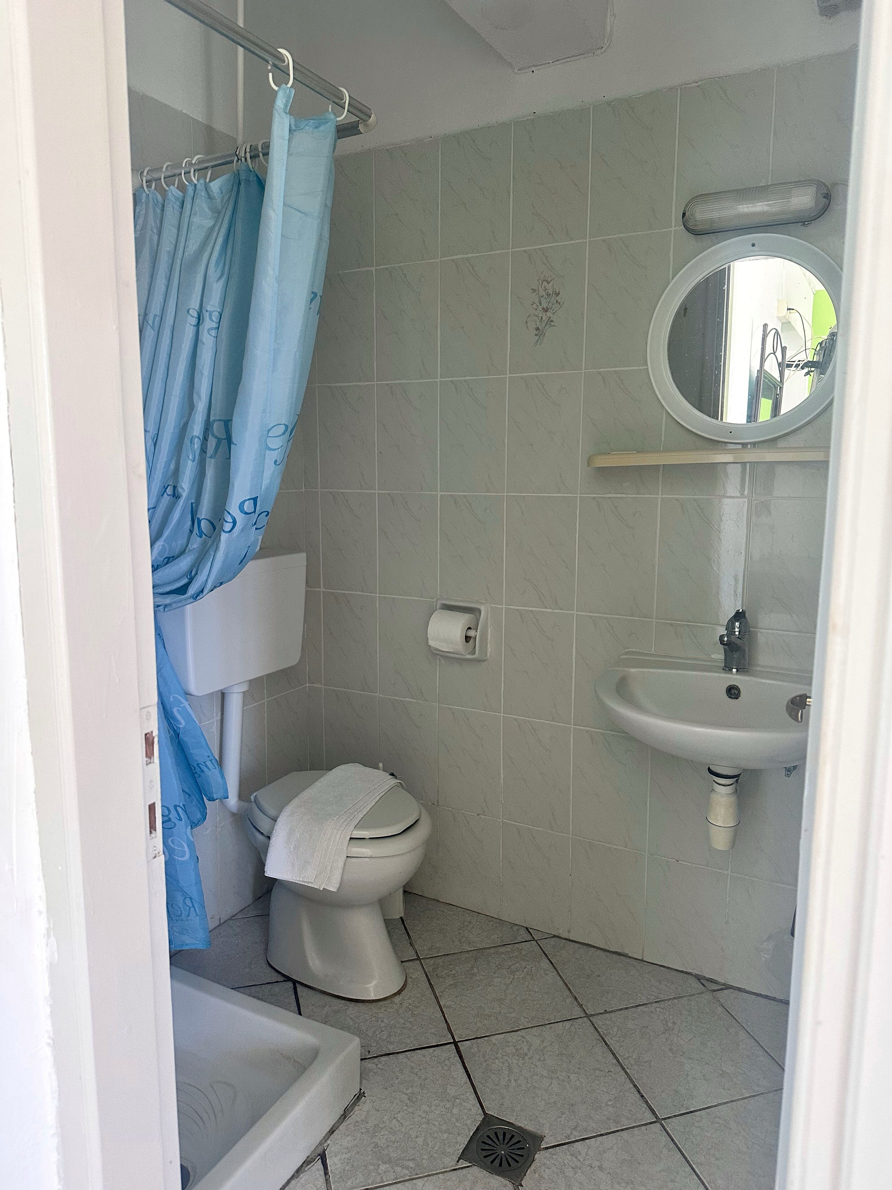 Un bany petit amb vàter, rentapel i plat de dutxa.
