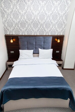 Ropa de cama hipoalergénica y caja de seguridad en la habitación 