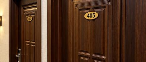 Deux portes en bois, portant les numéros 403 et 405, toutes deux dotées d’une poignée moderne et d’un trou de serrure.