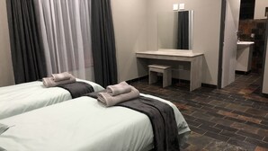 A hotel room with two beds, a small desk, a mirror, and a bathroom visible through an open door. - Spendpenny Guest Farm (Kgetlengrivier)