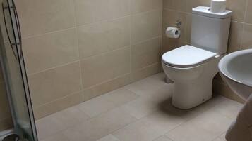 A bathroom with a skylight, a toilet, and a sink.