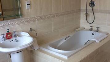 A bathroom with a sink, bathtub, and shower.