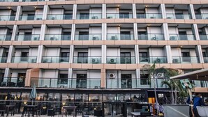 Un hôtel à plusieurs étages doté de balcons, d’un espace extérieur aménagé et d’une façade en verre.