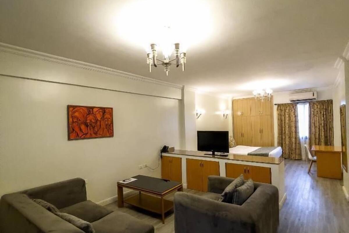 A living room with two sofas, a coffee table, a TV, and a wooden cabinet.