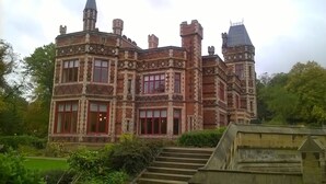 Un edificio grande y de estilo histórico, con múltiples torres y una entrada destacada.