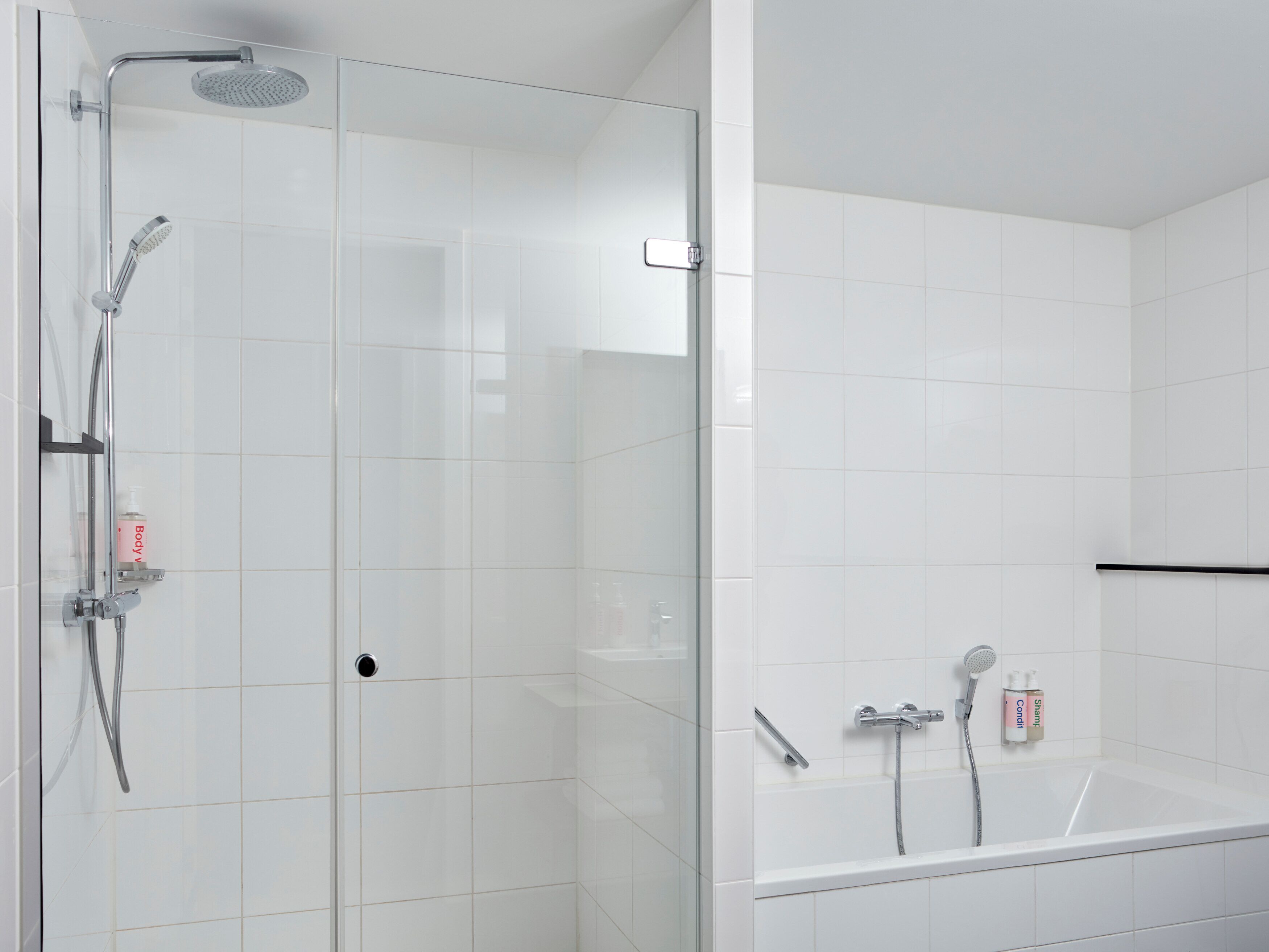 Un baño moderno con ducha envuelta en vidrio, bañera separada y un inodoro.