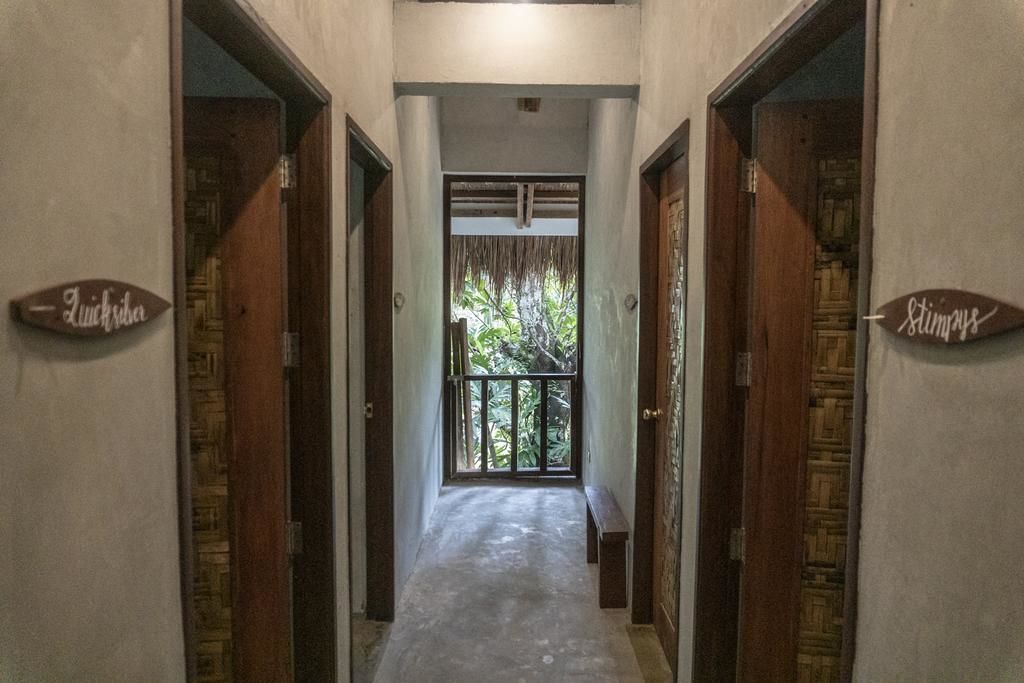 A hallway with two doors labeled "Quicksilver" and "Stimpays," leading to a balcony with a view of greenery.