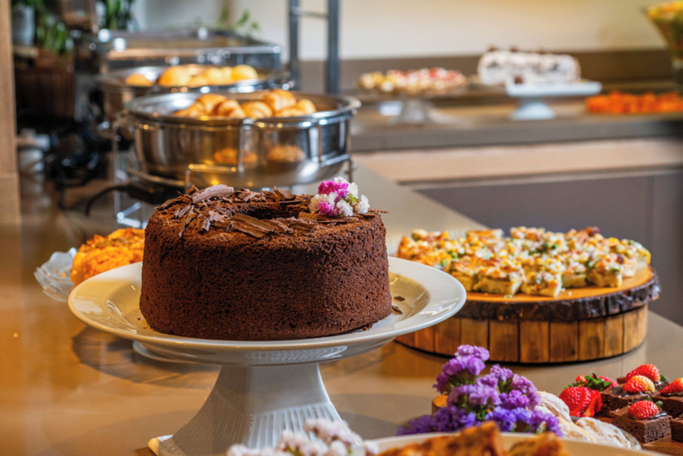 A buffet with various desserts including a chocolate cake, pastries, and fruit tarts.