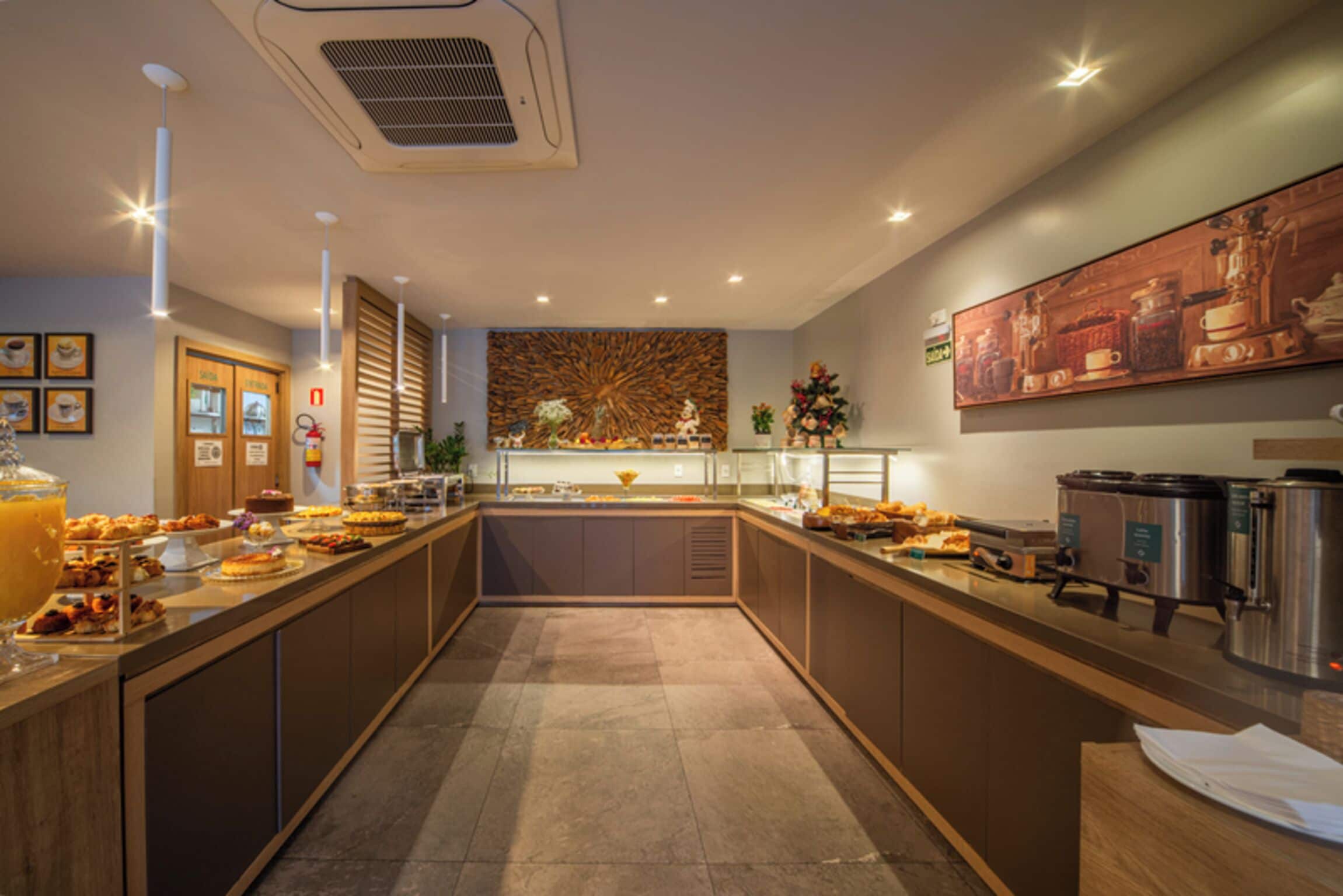 A modern kitchen with a central island, equipped with various appliances and a buffet setup.