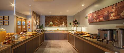 A modern kitchen with a central island, equipped with various appliances and a buffet setup.