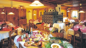Un restaurant au décor intérieur en bois, doté de nombreuses tables et de luminaires suspendus.