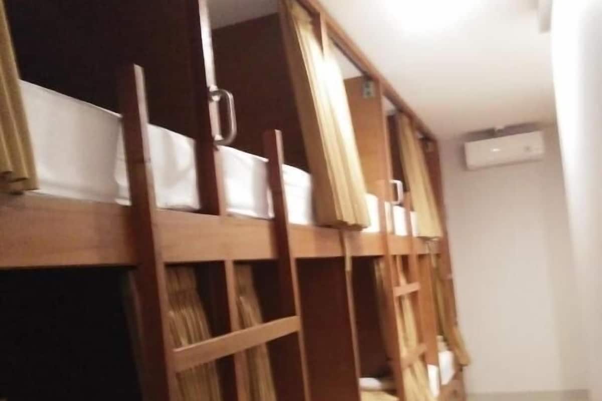 A bunk bed room with wooden frames and white bedding.