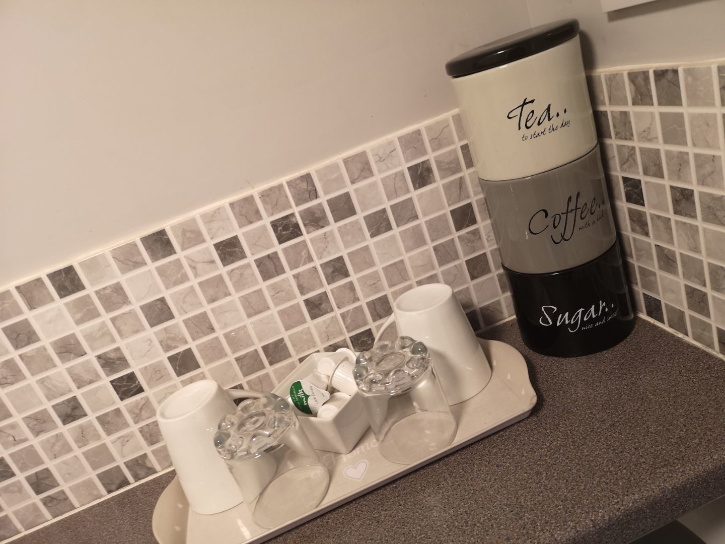 A coffee maker with a label that reads "Tea... Coffee... Sugar... nice and sweet."