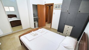 Une chambre d’hôtel avec un lit, une armoire et un miroir.