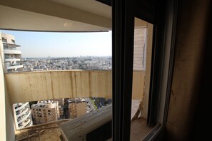 A balcony with a city view, including buildings and a clear sky. - Arendalzrail Apartments - Yoseftal Street 3 (Bat Yam)