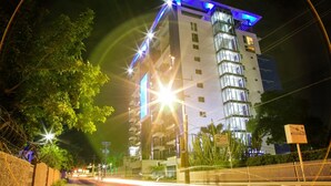 A multi-story hotel with a modern design, featuring a prominent glass facade and illuminated signage. - Ultra Luxury Apartment at  20 South (Kingston)