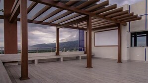 An open terrace with a pergola structure, a view of mountains, and a distant bridge. - Ultra Luxury Apartment at  20 South (Kingston)
