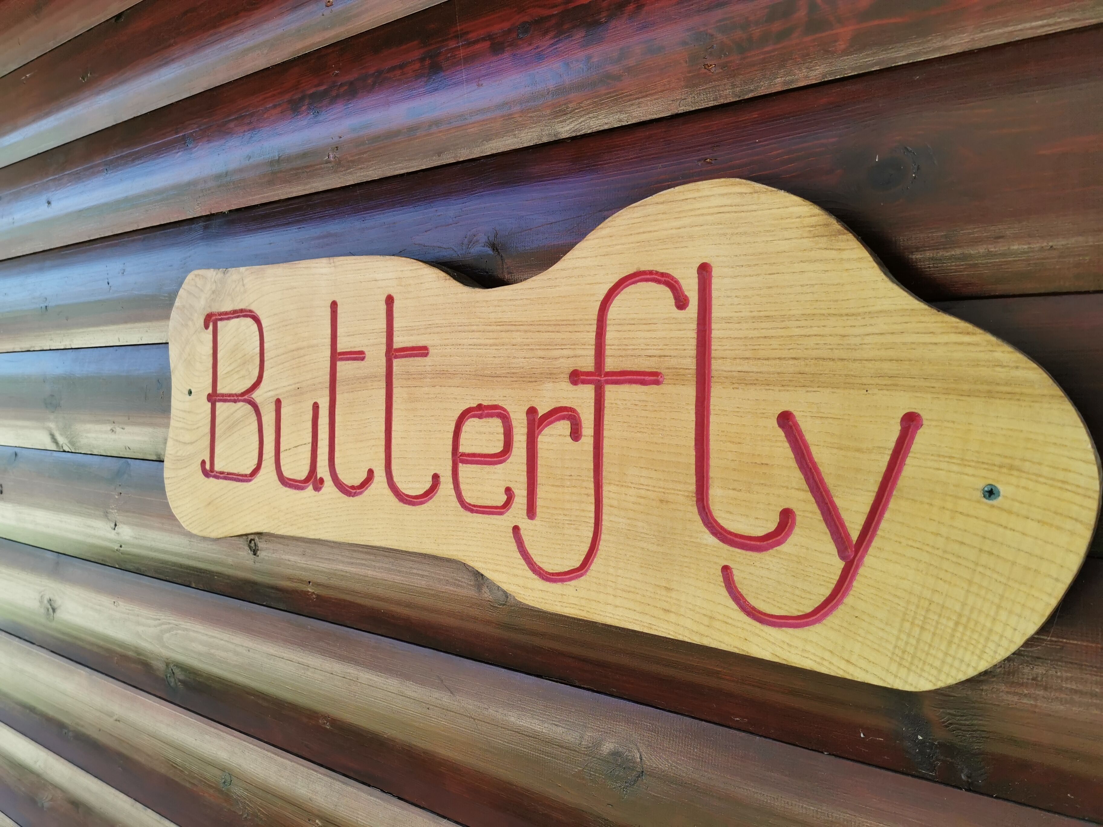 A wooden sign with the word "Butterfly" in red letters.