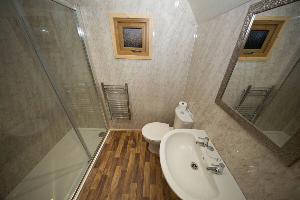 Un bagno con doccia, WC e lavandino.