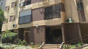 A multi-story building with balconies, air conditioning units, and a sign indicating a business or service. - Arendalzrail Apartment - Hertsel St. 4 (Bat Yam)