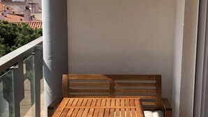 A wooden table and bench set on a balcony with a city view. - Attic Lo Pagan in Mar Menor (San Pedro del Pinatar)