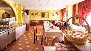 Un restaurante con mesas de madera y un buqué de pan en una cesta grande de mimbre.