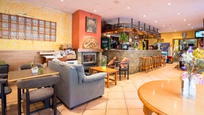 Un restaurante acogedor con barra, mesas y una chimenea.