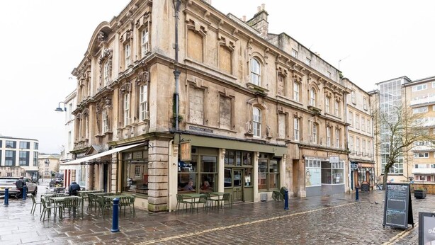 A historic building with a ground-floor shop and outdoor seating area. - The King's Meadery (Bath)