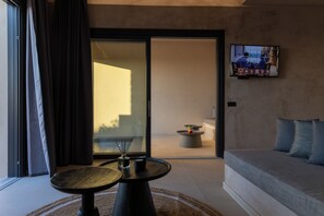Una sala de estar moderna con un sofá, una mesa de centro y un televisor montado en la pared.