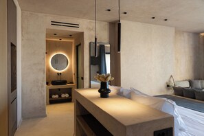Un bagno moderno con uno specchio rotondo, un lavandino e un vaso con fiori secchi.