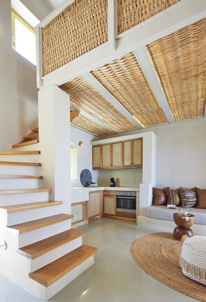 Un intérieur moderne comprenant un escalier, une cuisine et un coin salon.