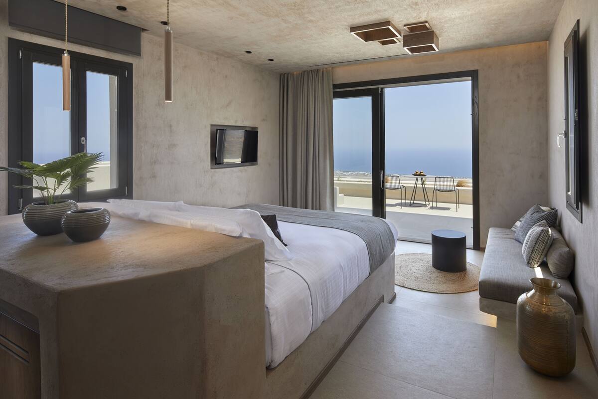 Une chambre moderne avec un grand lit, un canapé et une vue sur la plage.