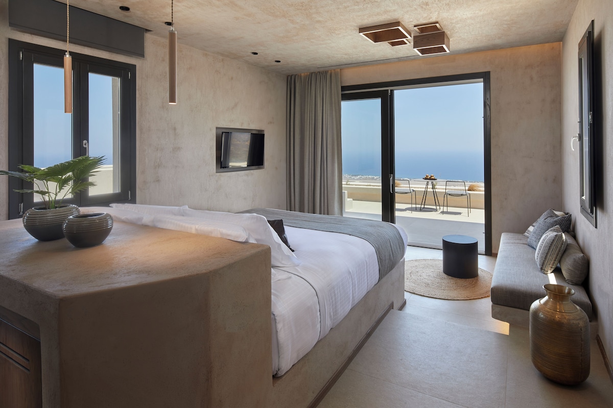 Un dormitorio moderno con una cama grande, un sofá y vistas a la playa.