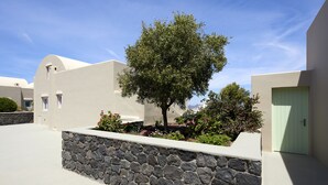 Un bâtiment moderne avec un mur en pierre et un arbre au centre.