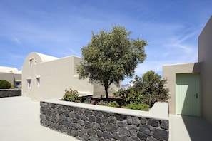 Un edificio moderno con una pared de piedra y un árbol en el centro.