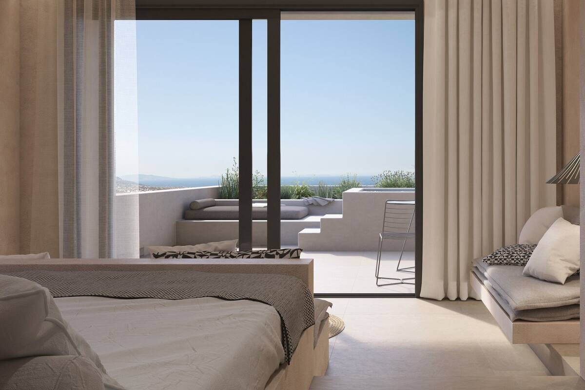 Une chambre d’hôtel moderne dotée d’un grand lit, d’un canapé et d’un balcon offrant une vue sur la ville.
