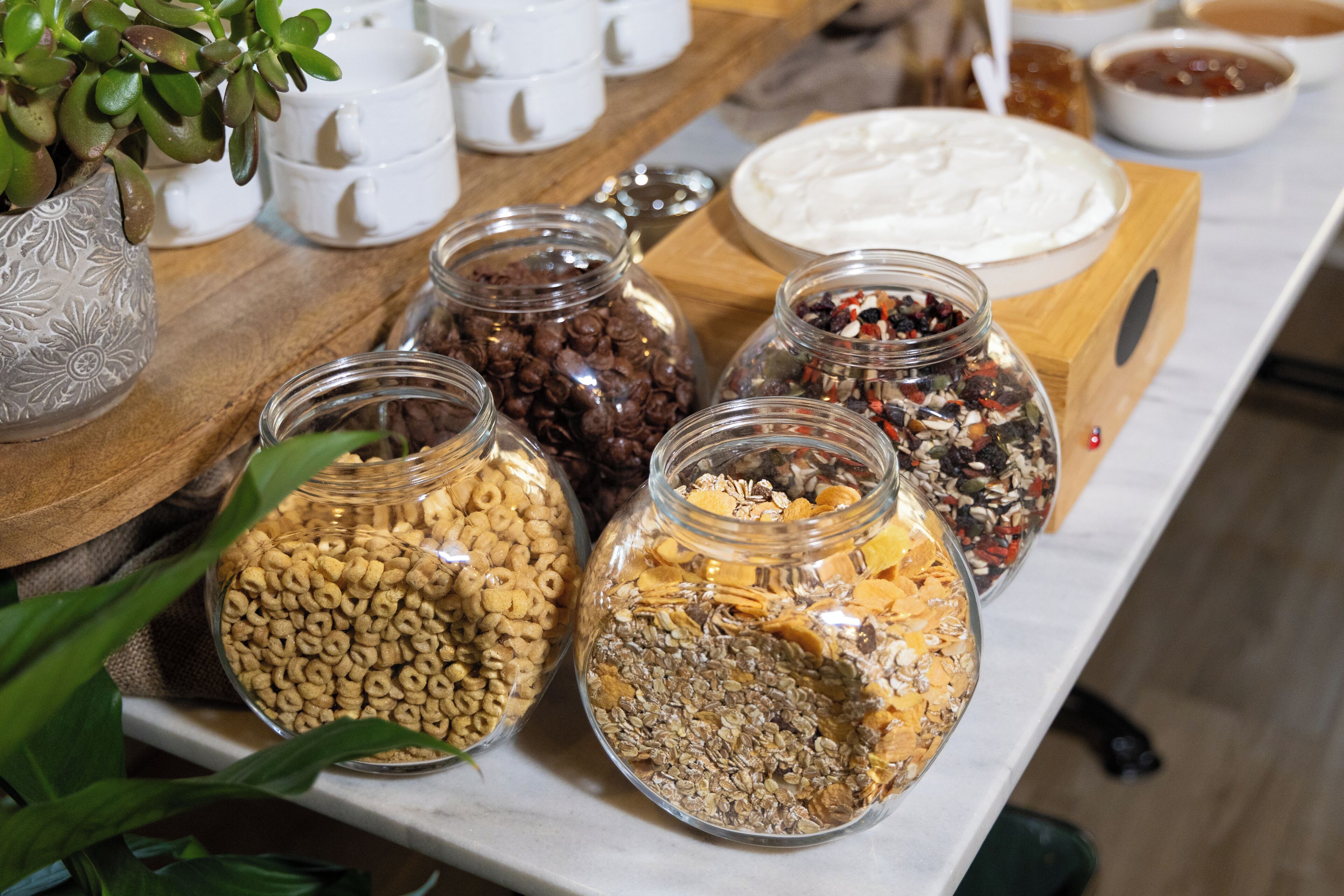 A table with various food items including jars of cereal, nuts, and dried fruits.