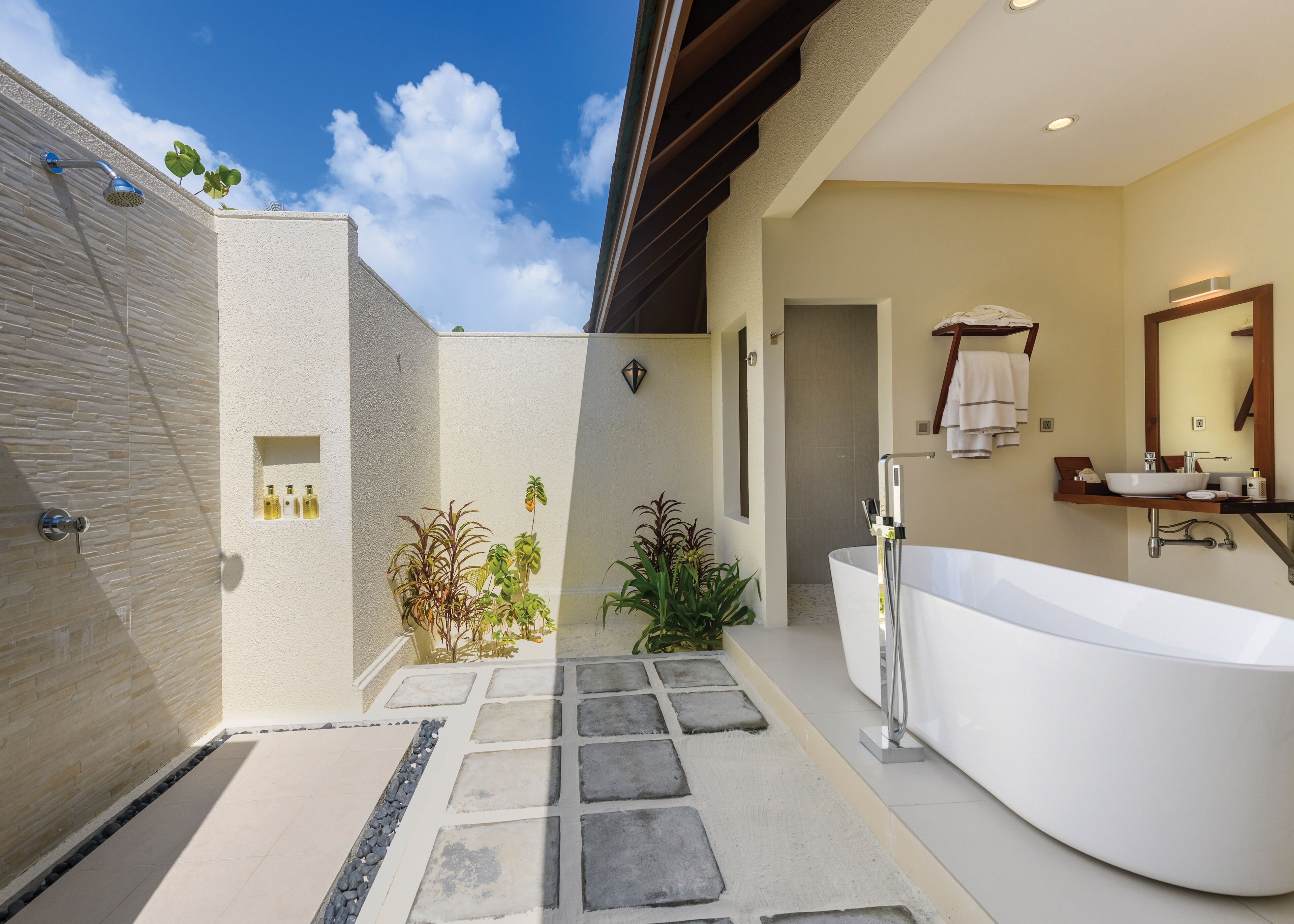 A modern bathroom with a freestanding bathtub, a shower, and a vanity with a large mirror.
