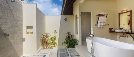 A modern bathroom with a freestanding bathtub, a shower, and a vanity with a large mirror.