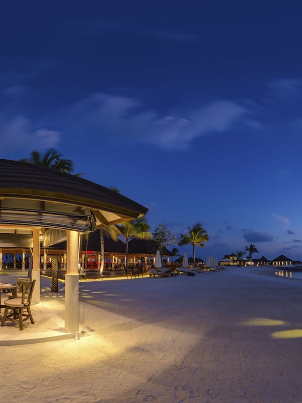 Relax by the ocean at this beachfront resort, where a covered dining area offers a round table and comfortable seating.