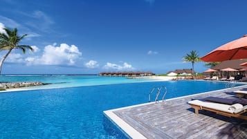 Una piscina al aire libre, sombrillas, tumbonas