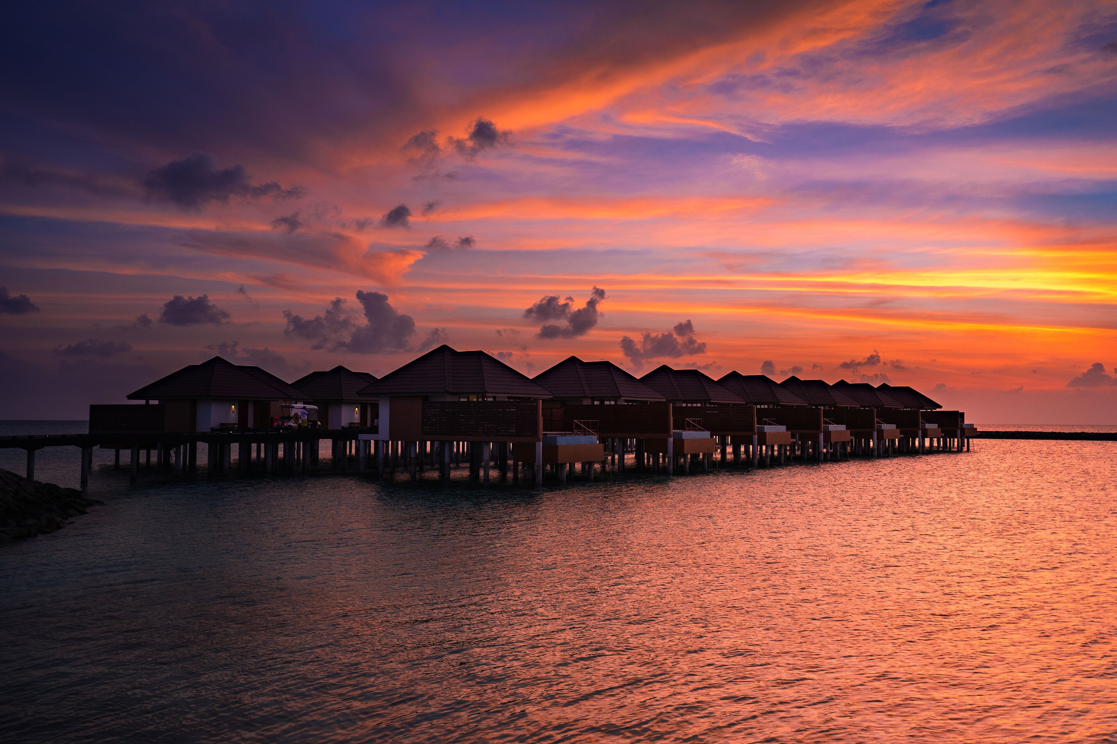 Overwater bungalows with a sunset view.