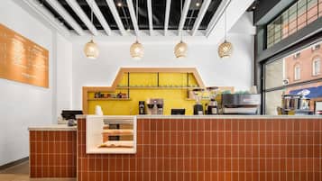 Um café moderno com balcão, cardápio e máquina de café.