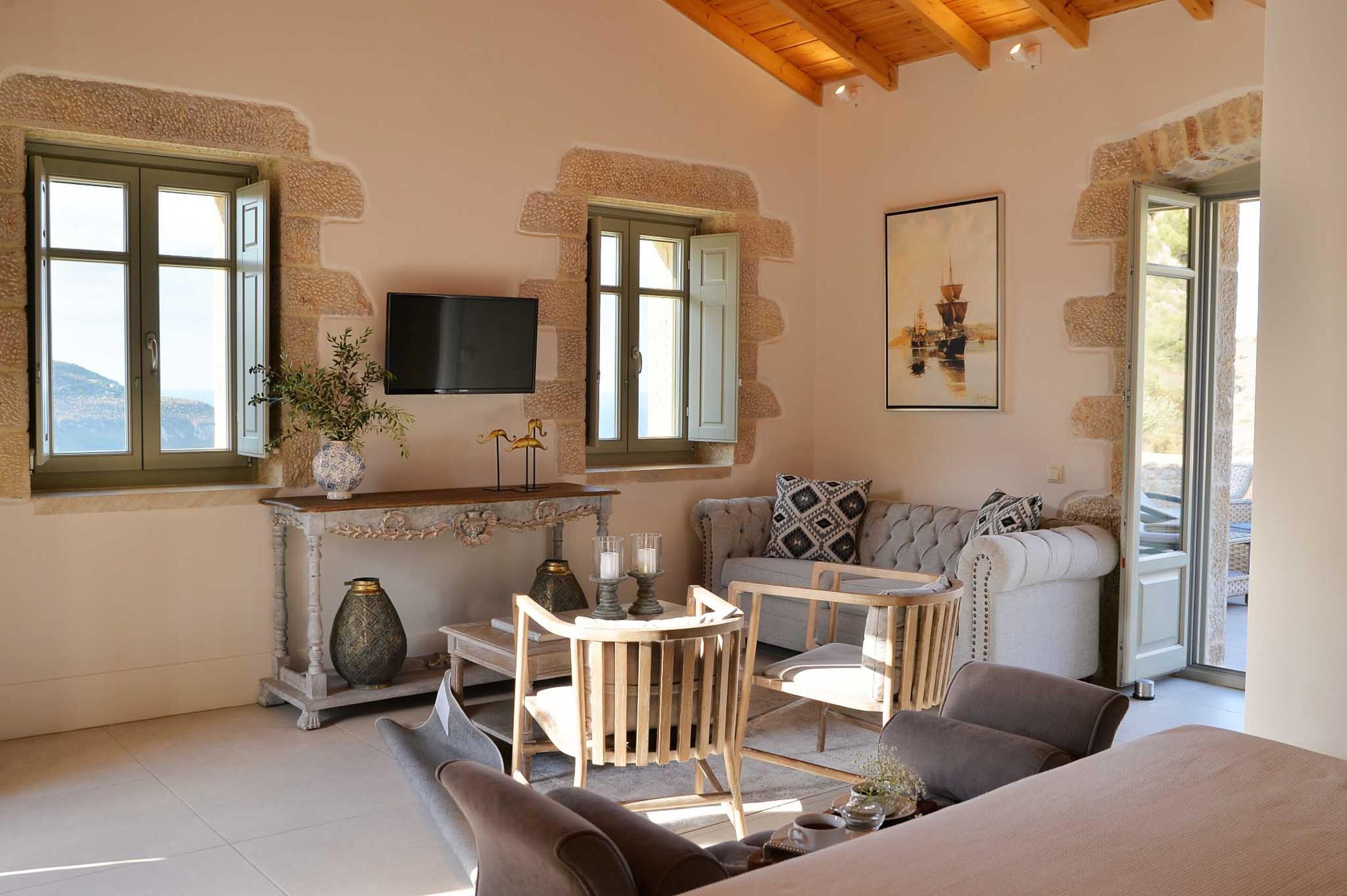 A cozy living room with a sofa, a small table, and a TV mounted on the wall.