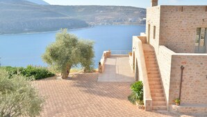 Un edificio de piedra con un patio empedrado y vistas a un lago y montañas.