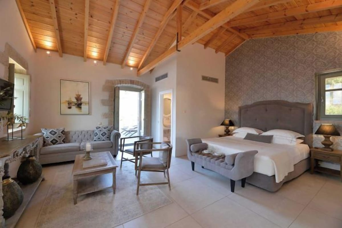 A bedroom with a bed, bedside tables, a sofa, and a chair.
