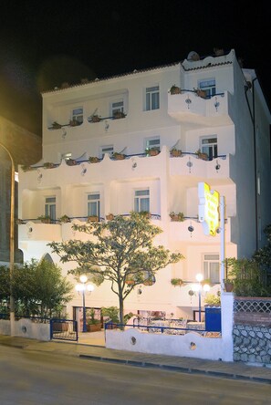 A multi-story hotel with balconies, potted plants, and a sign indicating it is a sports hotel. - Sporting Baia Dependence Villa Athena (Giardini Naxos)