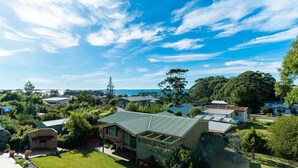 A residential area with houses, a stone structure, and a view of the sea. - Daybreak by Experience Jervis Bay (Vincentia)