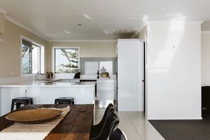 Dishwasher, electric kettle, cookware/dishes/utensils - Beachfront Apartment with Ocean Views (New Plymouth)